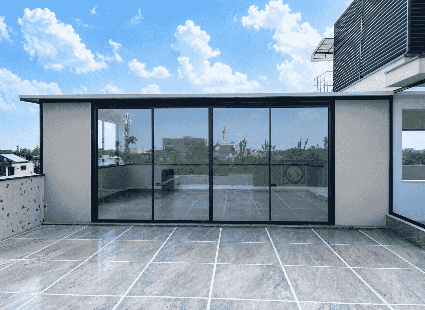 Glass room on a Delhi NCR terrace with full-height sliding glazing